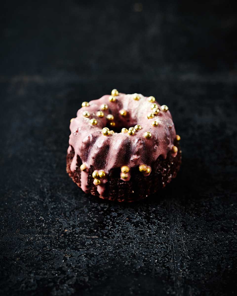 Foodfotografie kleines Törtchen mit rosa Zuckerguss und goldenen Perlen